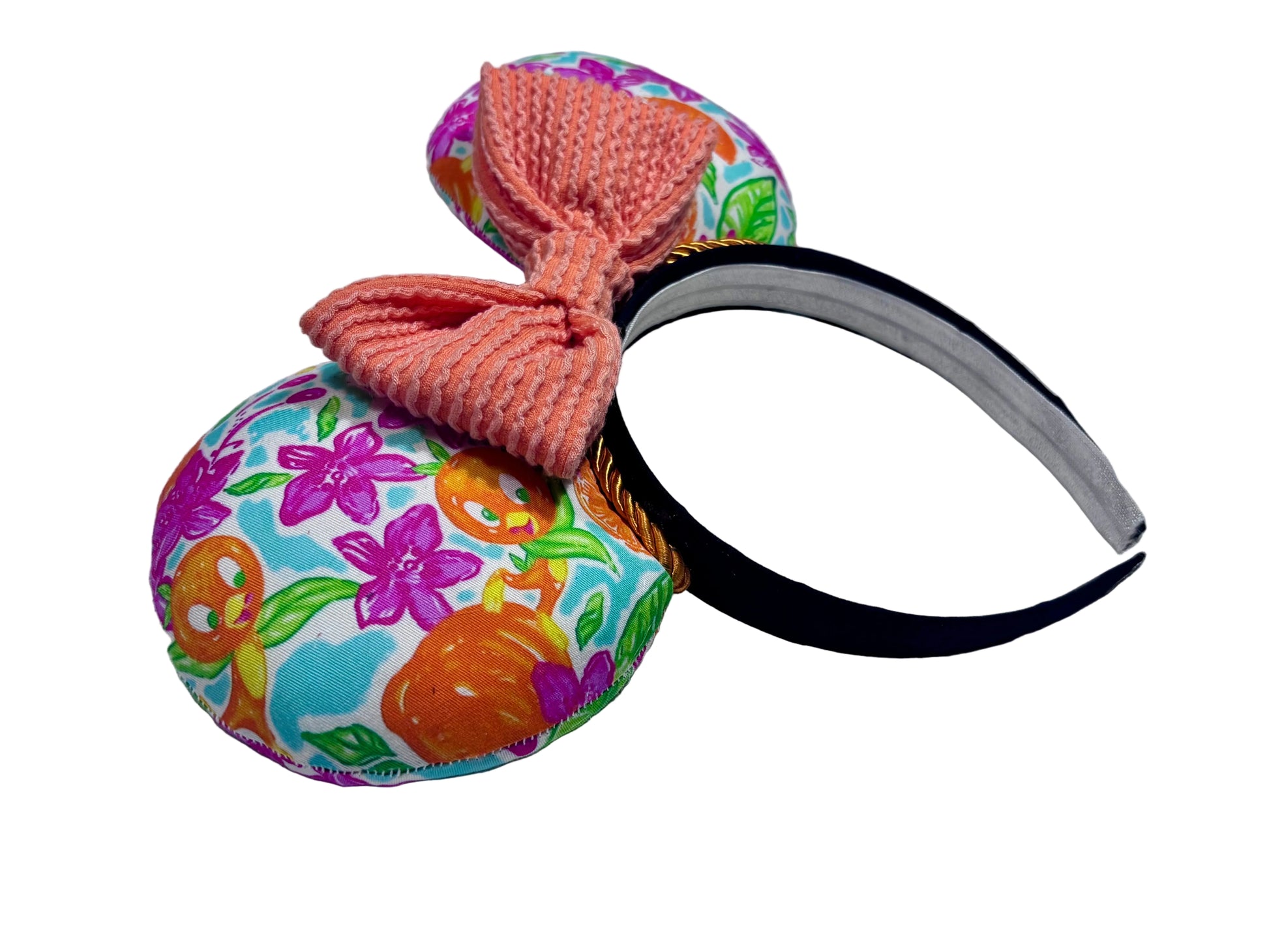 Colorful fabric headband with a orange waffle print bow on a textured surface