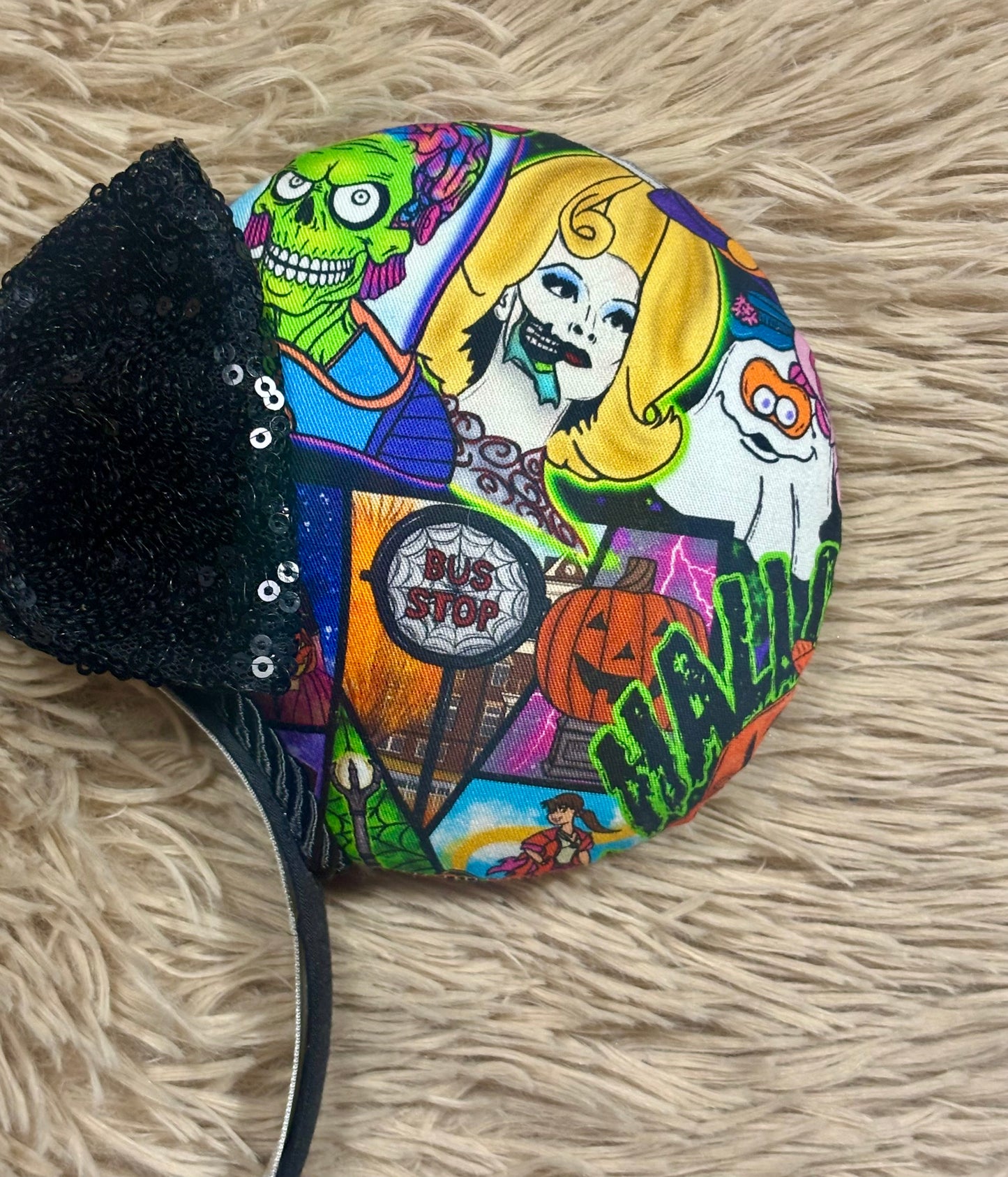 Close up of the front mouse ear with aliens, ghosts and other 90's Halloween images. 