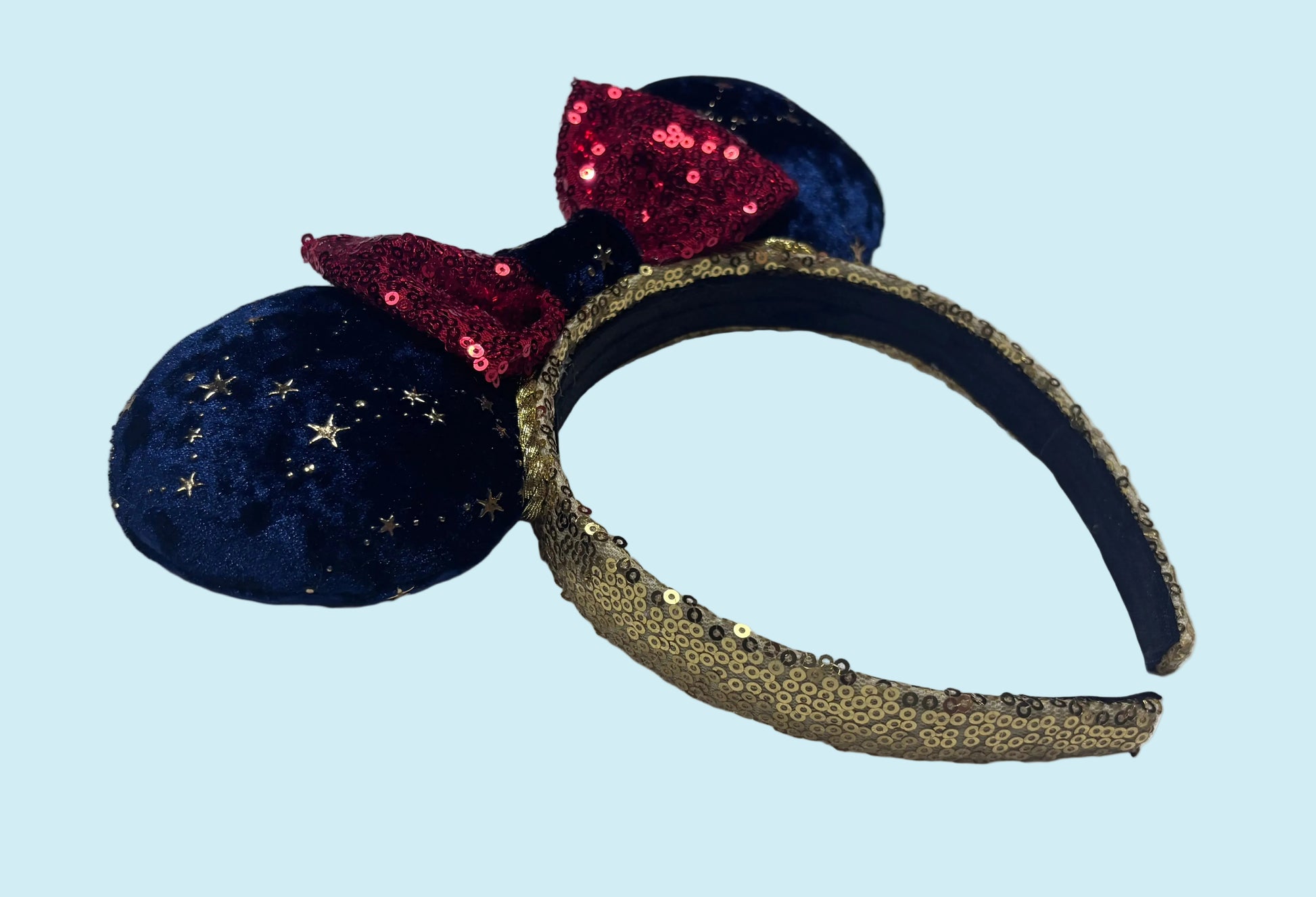 Navy blue headband with gold accents and red sequin bow on a gold sequin headband.