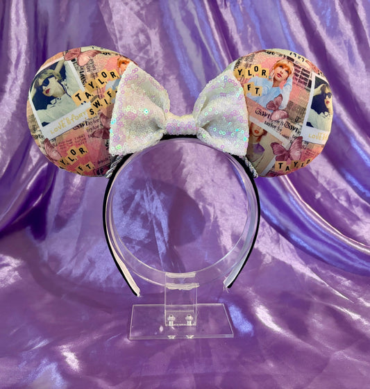 Handmade and ready to ship Taylor Inspired mouse ears. The character fabric is on the front and the back. On a universal sized black poly fabric headband. With a white iridescent sequin bow.