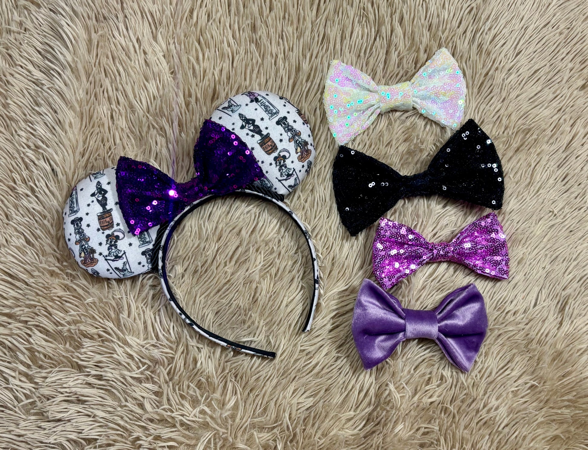 A set of ears with a fab 5 stretching room fabric on the ears front and back along with the headband as well. Black twisted trim along the inner ears with a purple sequin bow. Shown with various bow color options in white, black, lavender and a purple velvet bow in case you don/t want the default purple sequin.