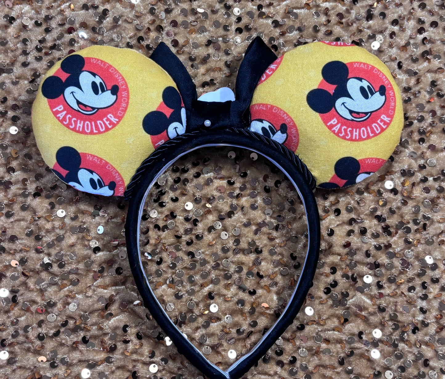 Back view of the AP Mouse ears with yellow passholder design on a sequined background