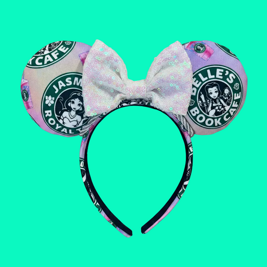 Handmade and ready to ship custom ears with popular coffee themed with princesses on fabric. White iridescent bow and silver twisted trim on a universal sized headband with matching design as the mouse ears.