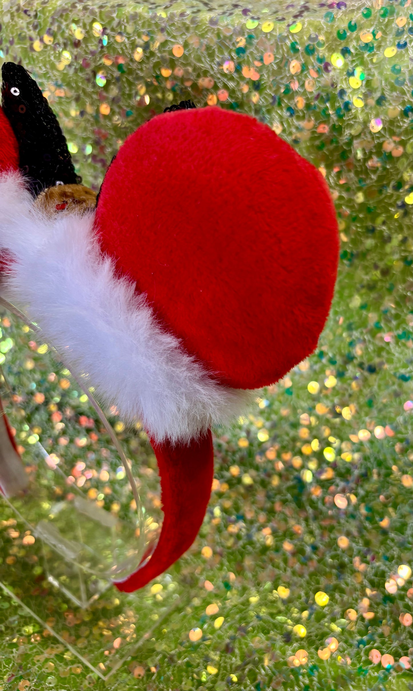 Minnie Mouse ears headband with red plush ears and black bow with gold middle and fluffy white trim on a white background