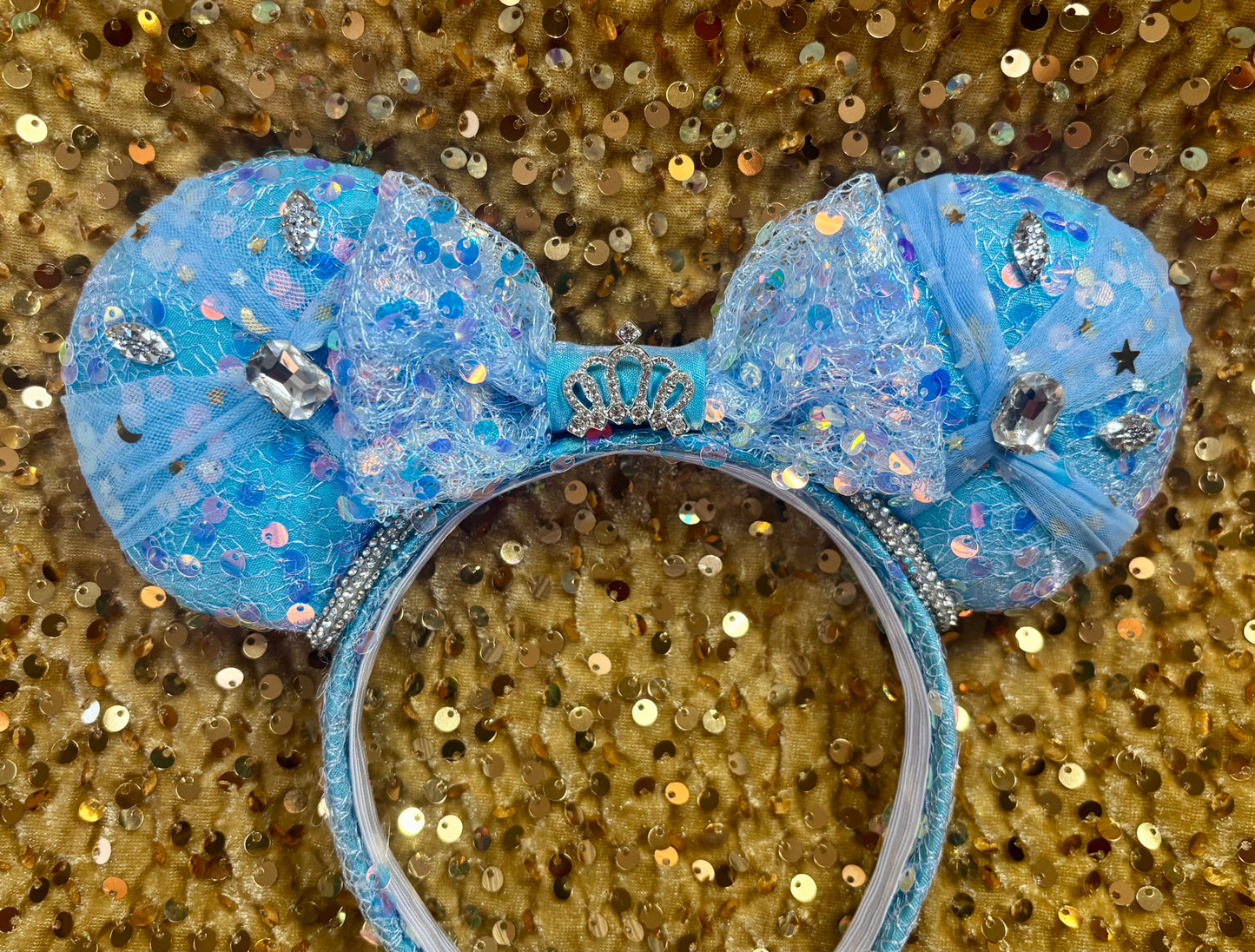 Handmade and ready to ship blue sequin mouse ears headband inspired by Cinderella with tulle and silver gemstones with a crown charm middle and rhinestone trim along inner ears.