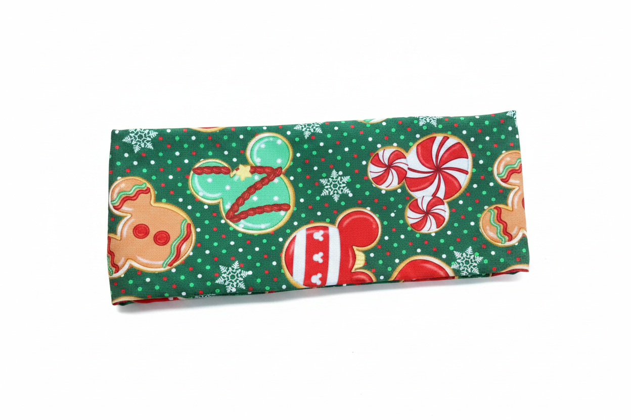 Christmas-themed fabric wrap shown from the back with gingerbread men, candy canes, and snowflakes on a green headwrap.