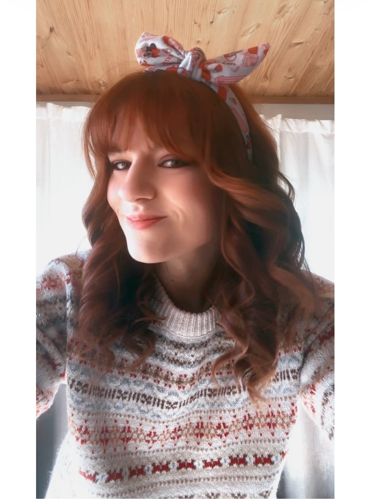 Model Tam wearing the Stocking Stuffers headband with a bow indoors.
