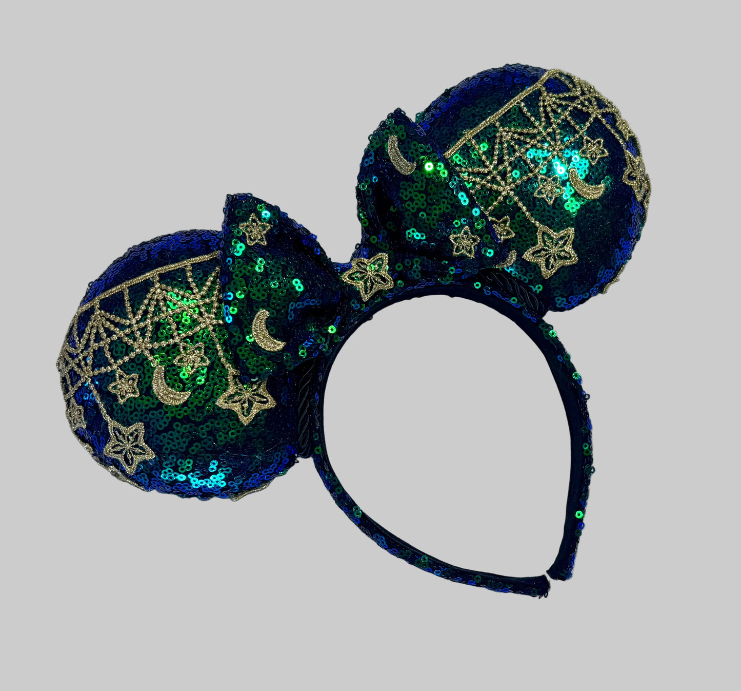 Mouse Ear headband that is a Handmade Iridescent blue and green sequins with gold sun, moon and stars attached to them. bow with star and moon patterns.