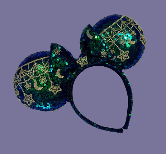 Mouse Ear headband that is a Handmade Iridescent blue and green sequins with gold sun, moon and stars attached to them. bow with star and moon patterns.