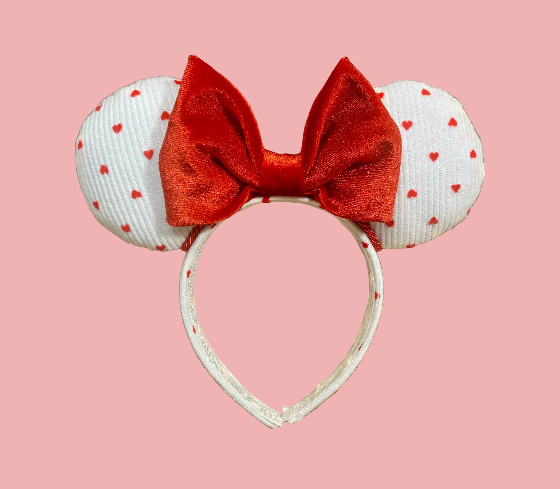 Handmade and ready to ship, Be Mine Custom Ears. Fabric is on ears front and back with red twisted trim along the inner ears and a big puffy plush red bow. The Headband is universal sized and has the same white fabric with hearts pattern on it.
