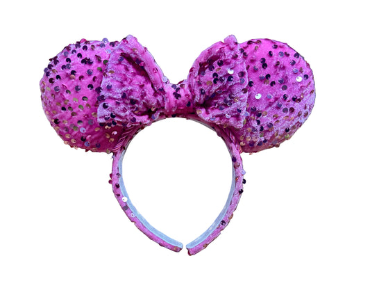 Pink glittery mouse ears on a white background