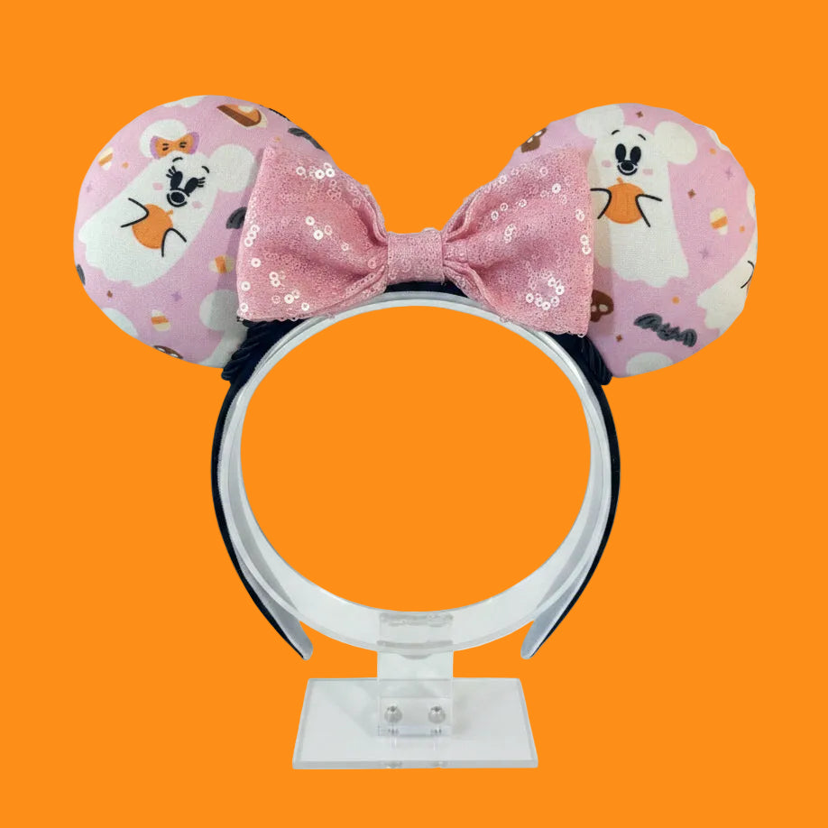 Handmade and ready to ship Halloween Pink Ghosts Mouse ears with the fabric with mouse shaped ghosts on pink fabric is on the ears, front and back and a light pink sequin bow. The headband is a universal sized headband and has black poly cotton fabric on it.