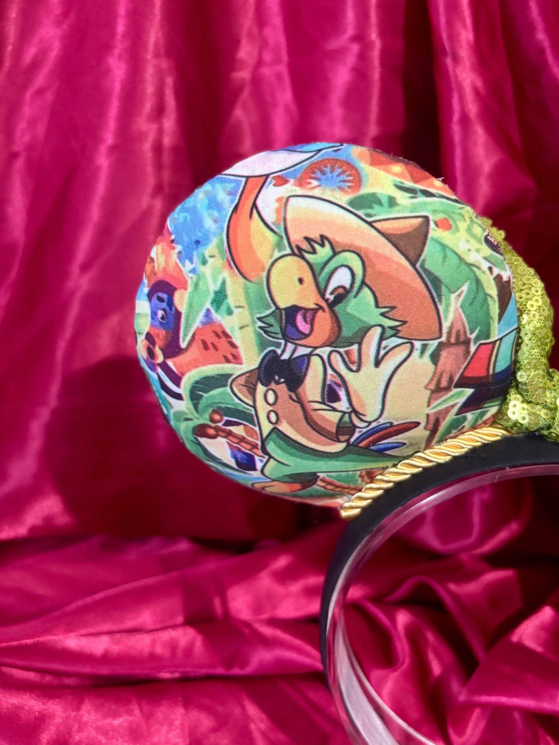 Colorful Handmade mouse ears with a green bow on a red satin background with duck Pablo cartoon images on the ears