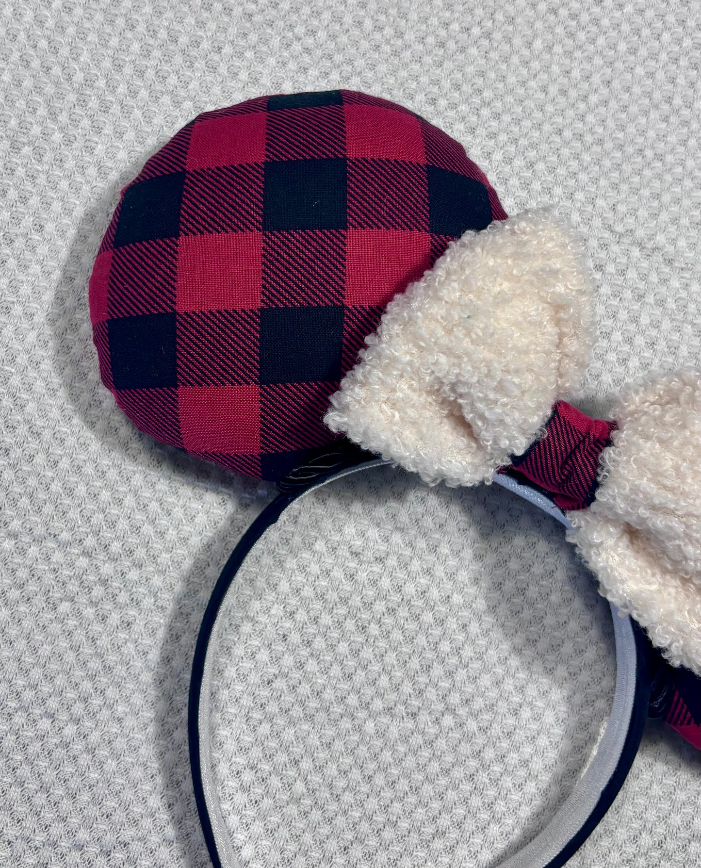 Handmade and ready to ship Buffalo Plaid mouse ears on both the front and back. On a black headband that is universal sized. The set has an off-white soft bow with buffalo plaid middle. Item is shown on a white background.