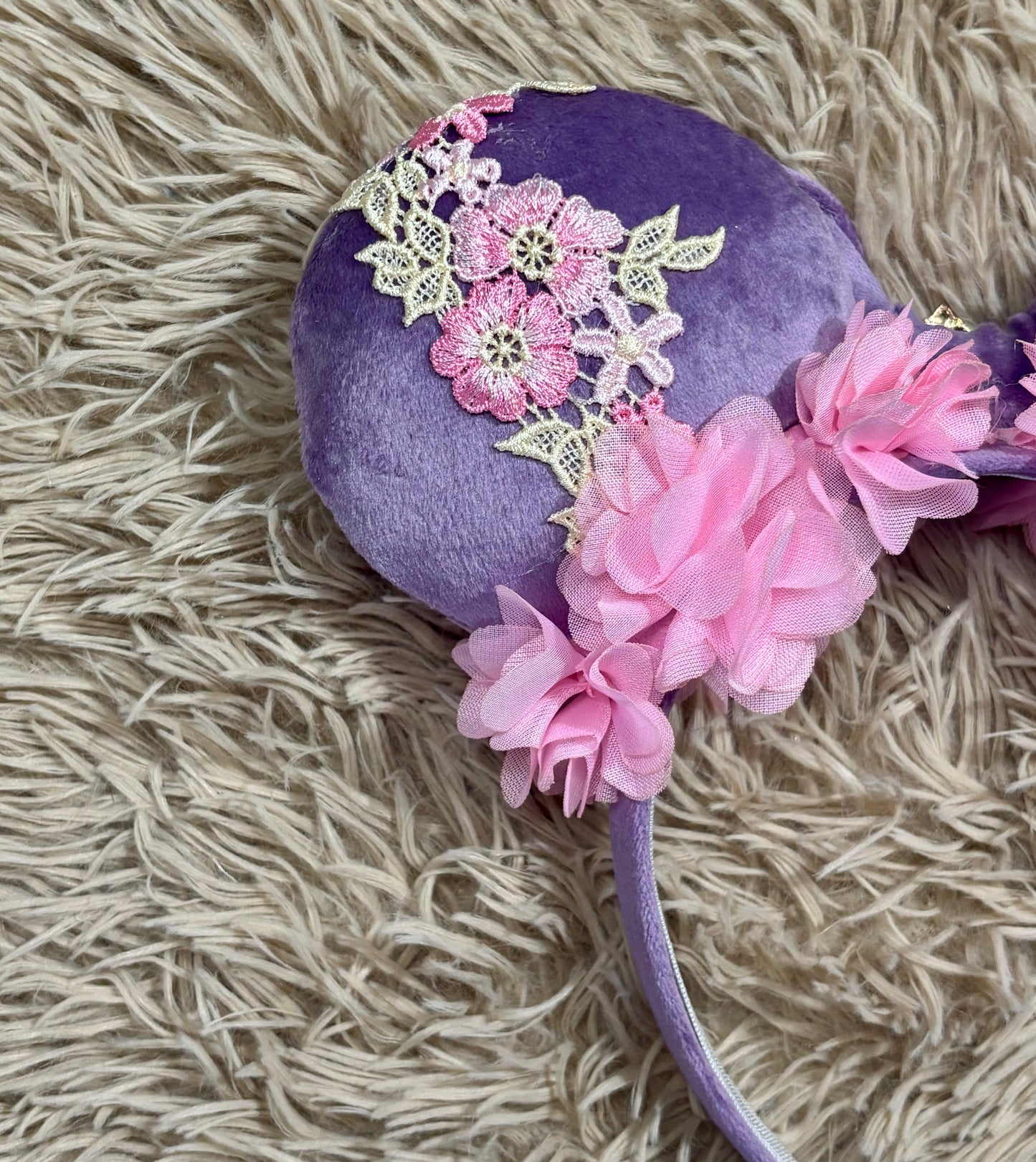 Purple and pink fabric mouse ears headband with a large velvet bow, floral lace appliques, and a purple gem accent.