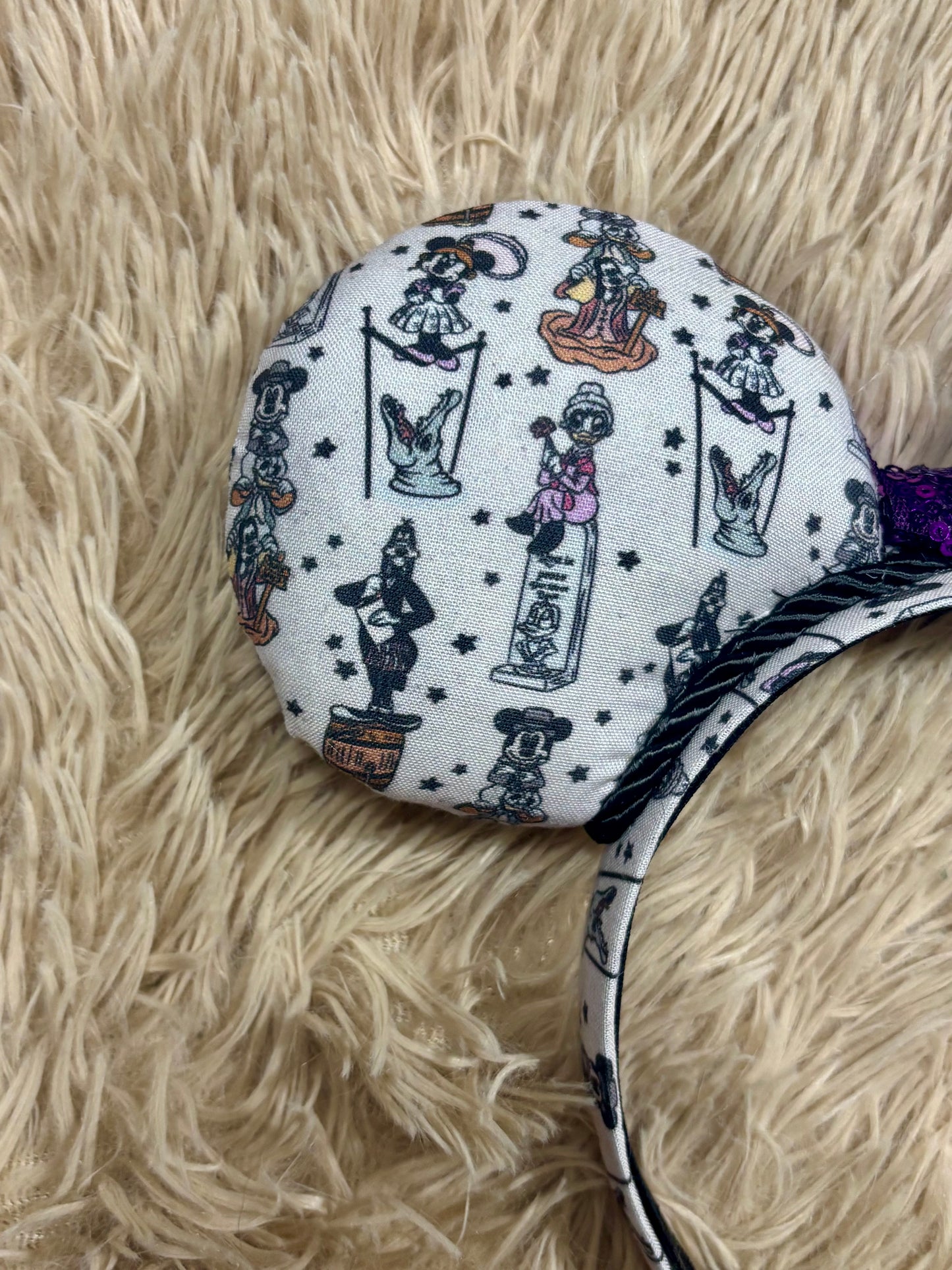 A set of ears with a fab 5 stretching room fabric on the ears front and back along with the headband as well. Black twisted trim along the inner ears with a purple sequin bow. 