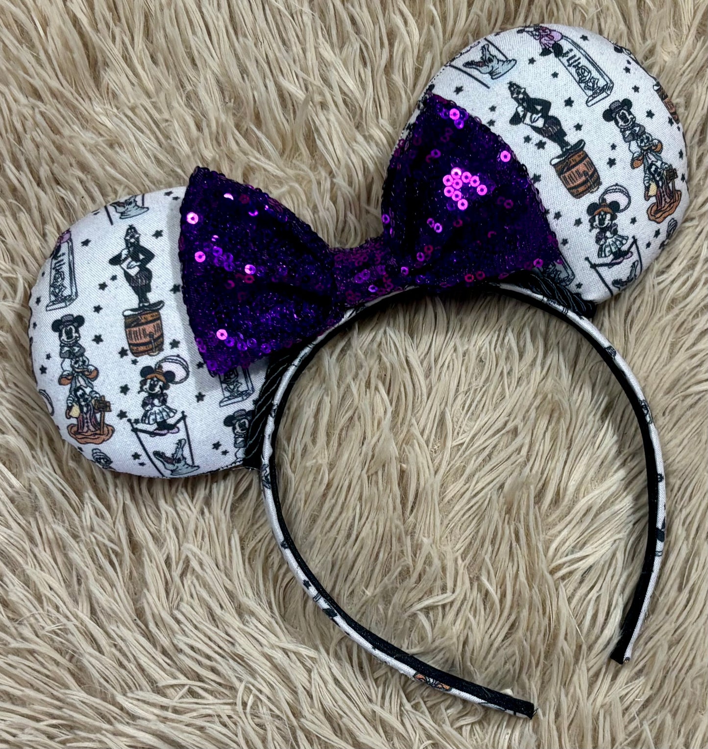 A set of ears with a fab 5 stretching room fabric on the ears front and back along with the headband as well. Black twisted trim along the inner ears with a purple sequin bow. 