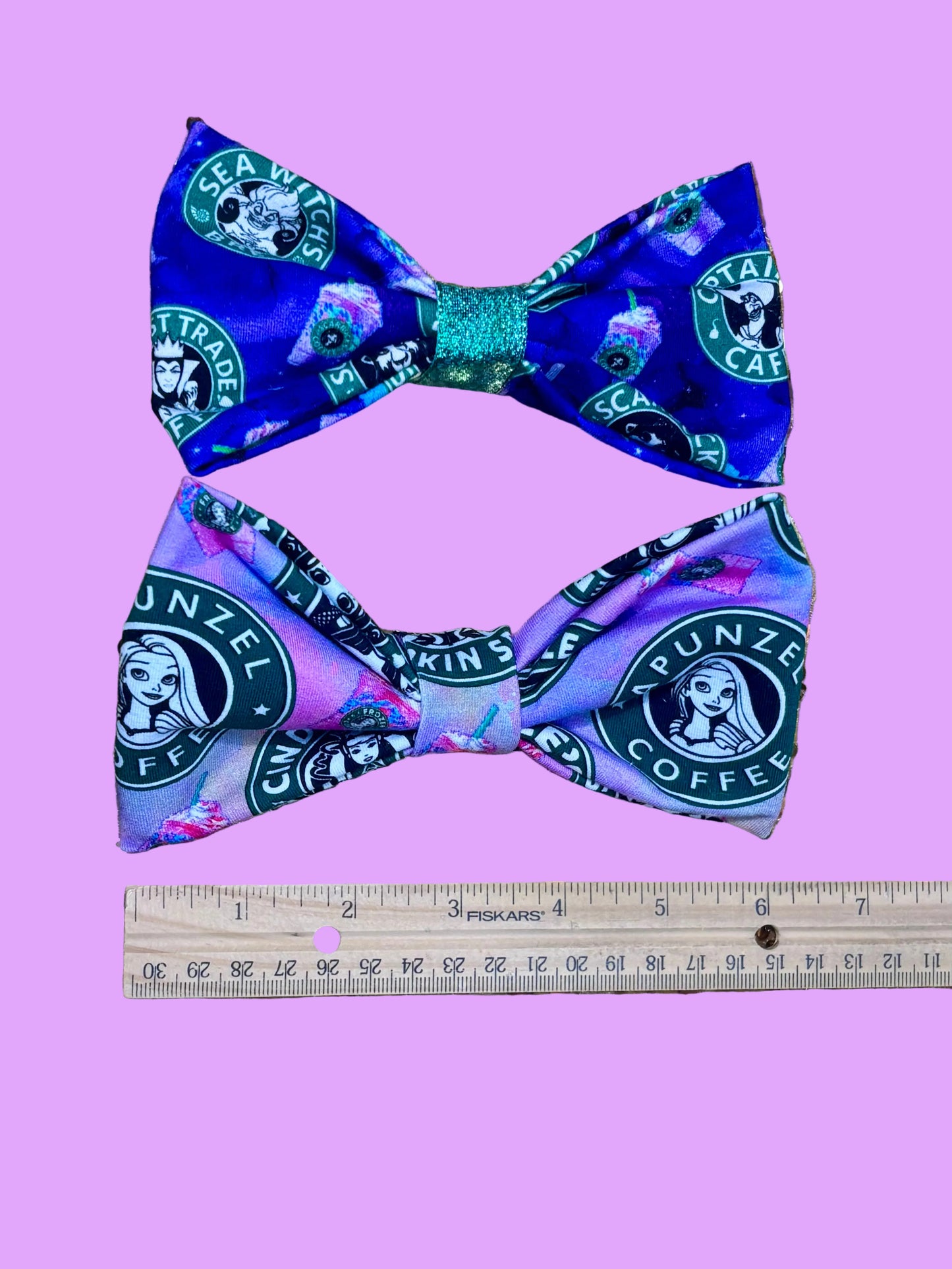 Handmade and ready to ship hairbows in a famous beloved coffee company's image but with princesses on one bow and villains on the other.  Shown with a rule for reference.