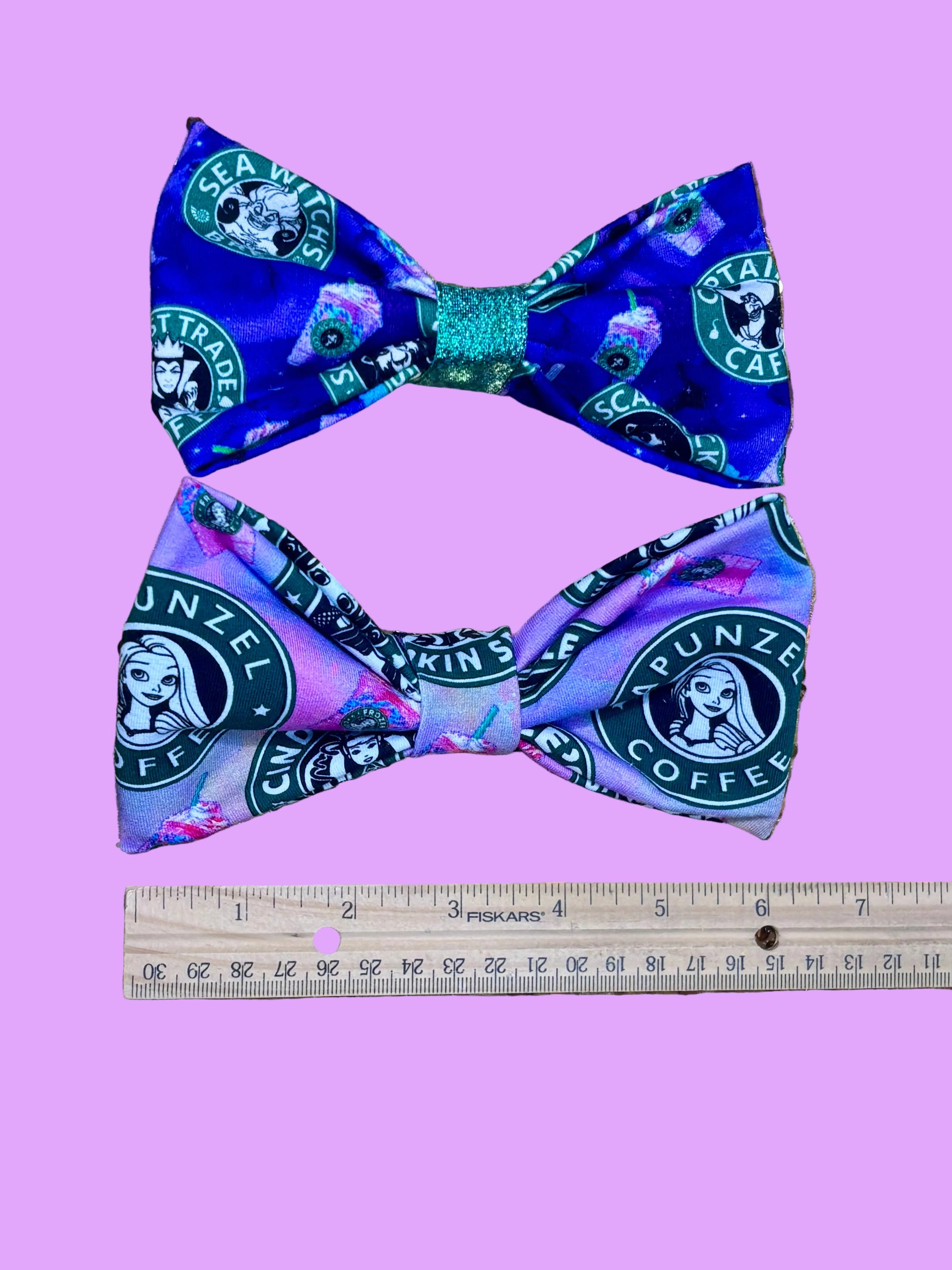 Handmade and ready to ship hairbows in a famous beloved coffee company's image but with princesses on one bow and villains on the other.  Shown with a rule for reference.
