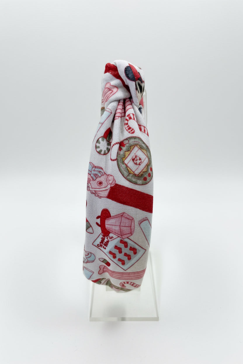 Side view of the Stocking Stuffers headband on a clear stand.