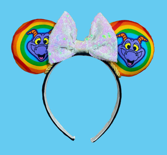 A purple dragon ear headband featuring colorful rainbow-striped ears with the Dragon and a large white iridescent bow on a black headband.