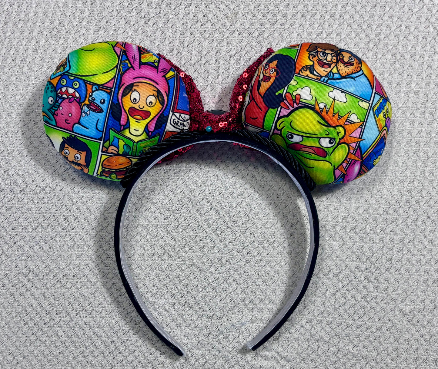 Colorful cartoon-themed headband with character designs on a white background