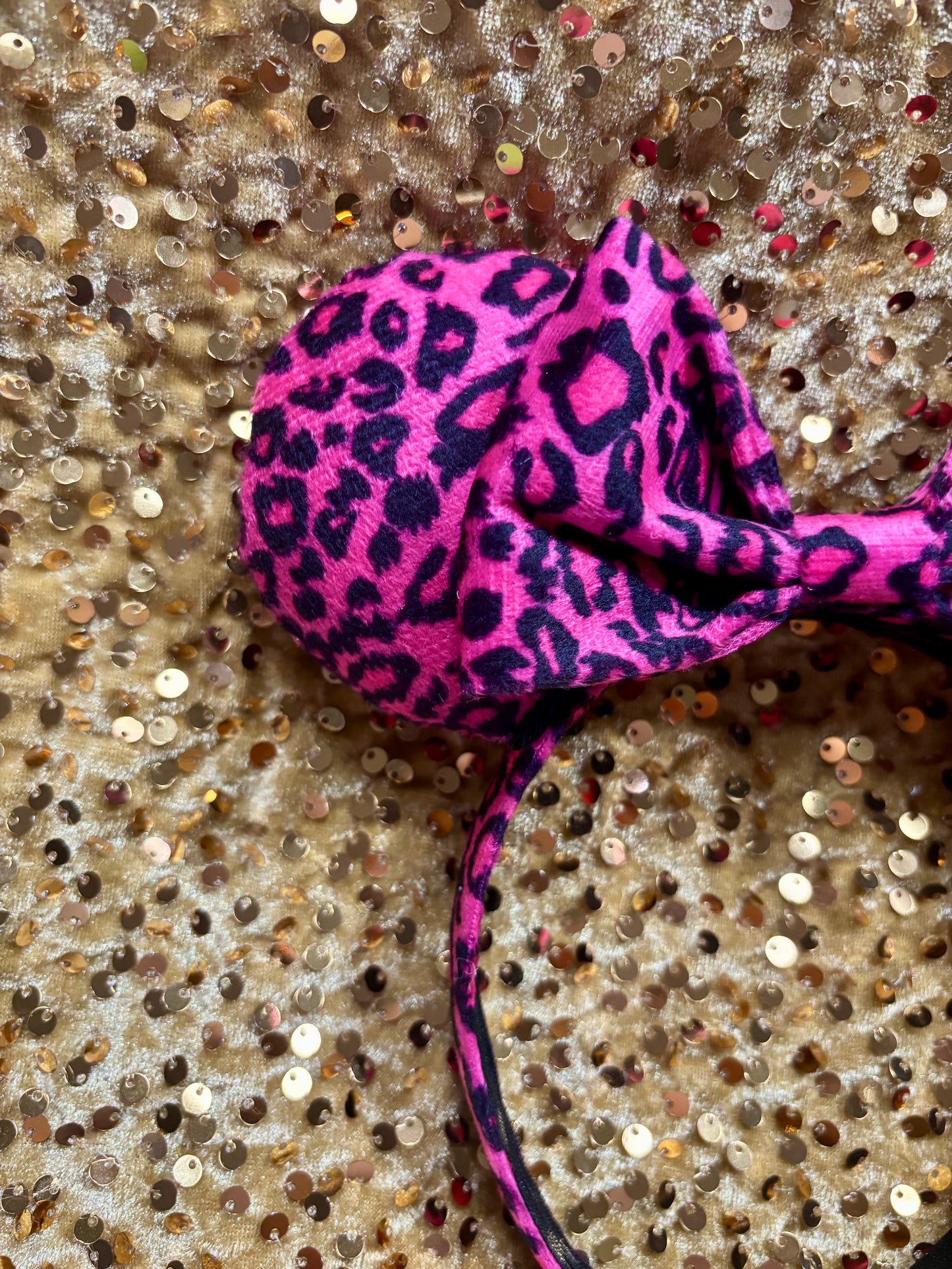 Pink headband with leopard print on a glittery surface