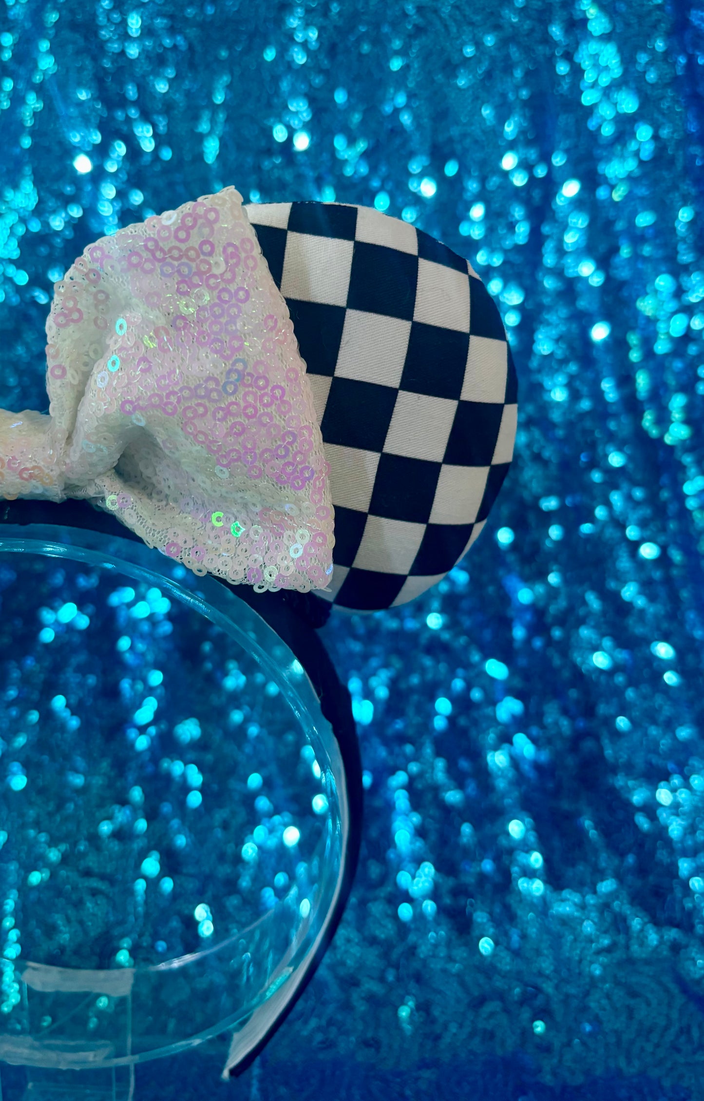 Checkered bow with sequin details on a blue glittery background