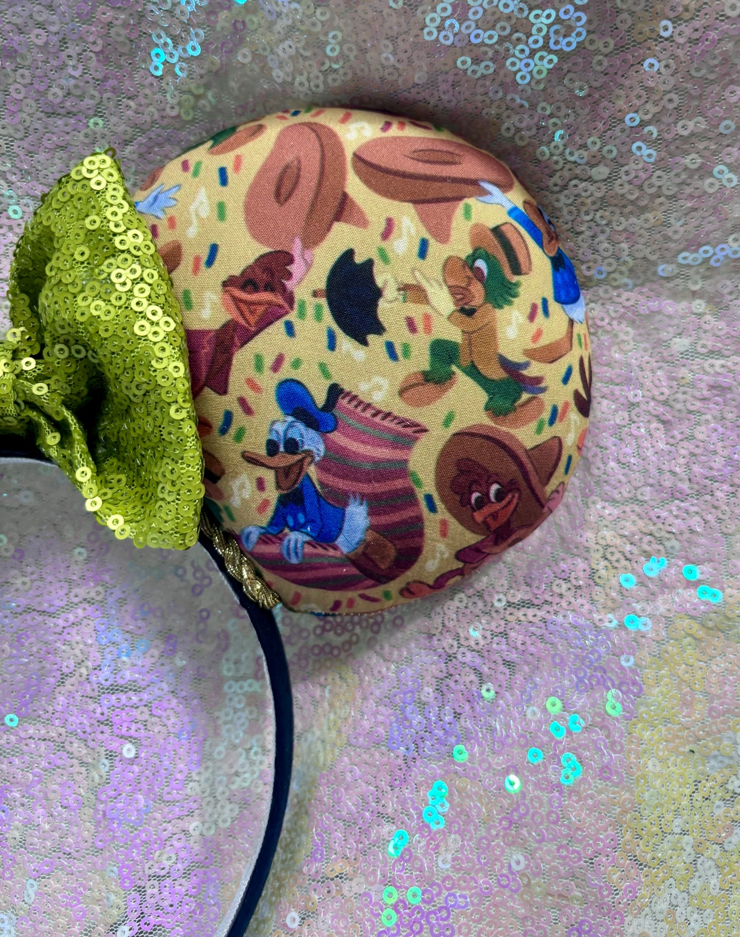 Handmade and ready to ship. These are perfect for Epcot. Three Caballero themed with a lime green sequin bow on a headband making mouse ears. Shown on a white glitter background.