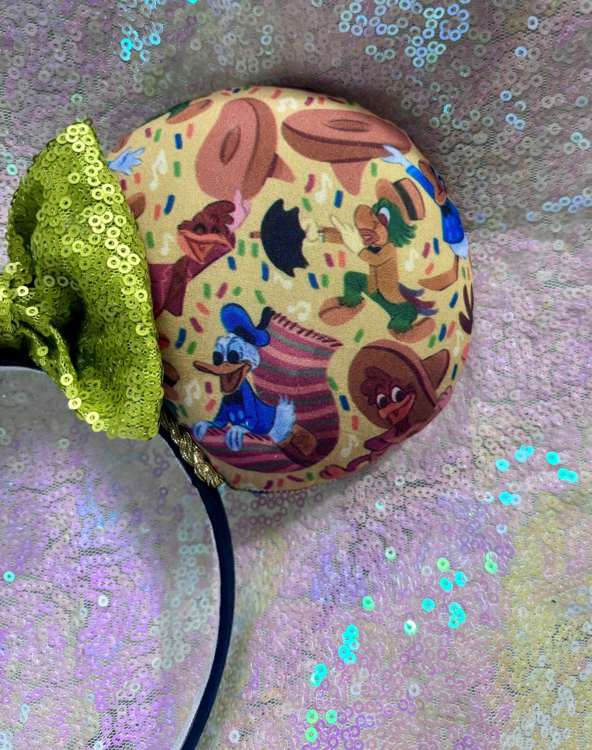 Handmade and ready to ship. These are perfect for Epcot. Three Caballero themed with a lime green sequin bow on a headband making mouse ears. Shown on a white glitter background.