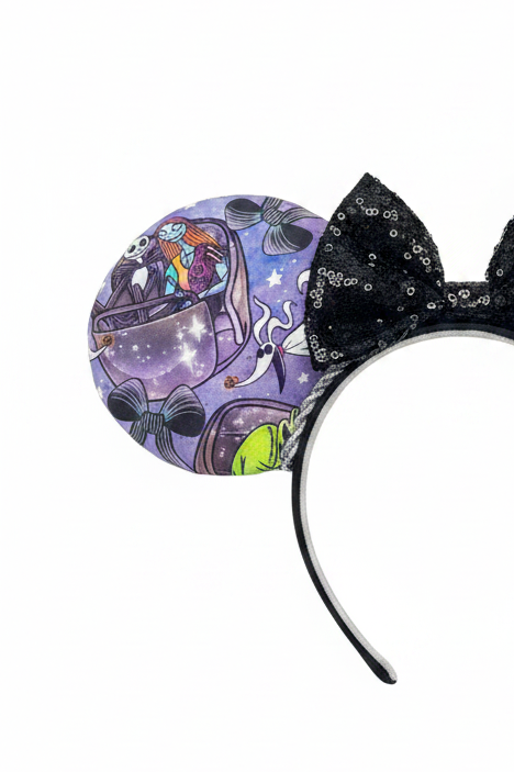 Handmade and ready to ship HM and NBC Mashup mouse ears. The fabric is on both the front and back. The headband is black and lined with white elastic. Shown with a black sequin bow. Item is shown on a white background.