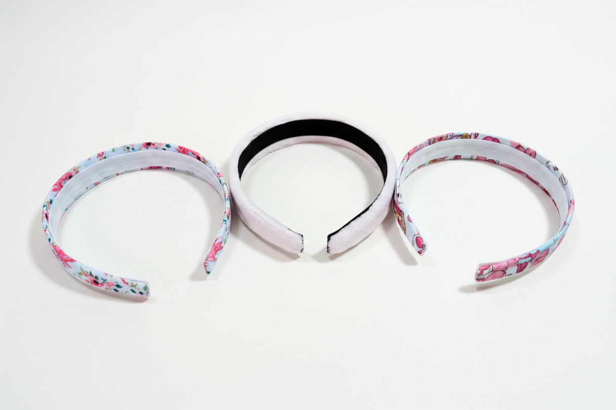 View of inner headbands. Three handmade and ready to ship headbands with floral castles, plush pink and MK cartoon designs on universal sized headbands.