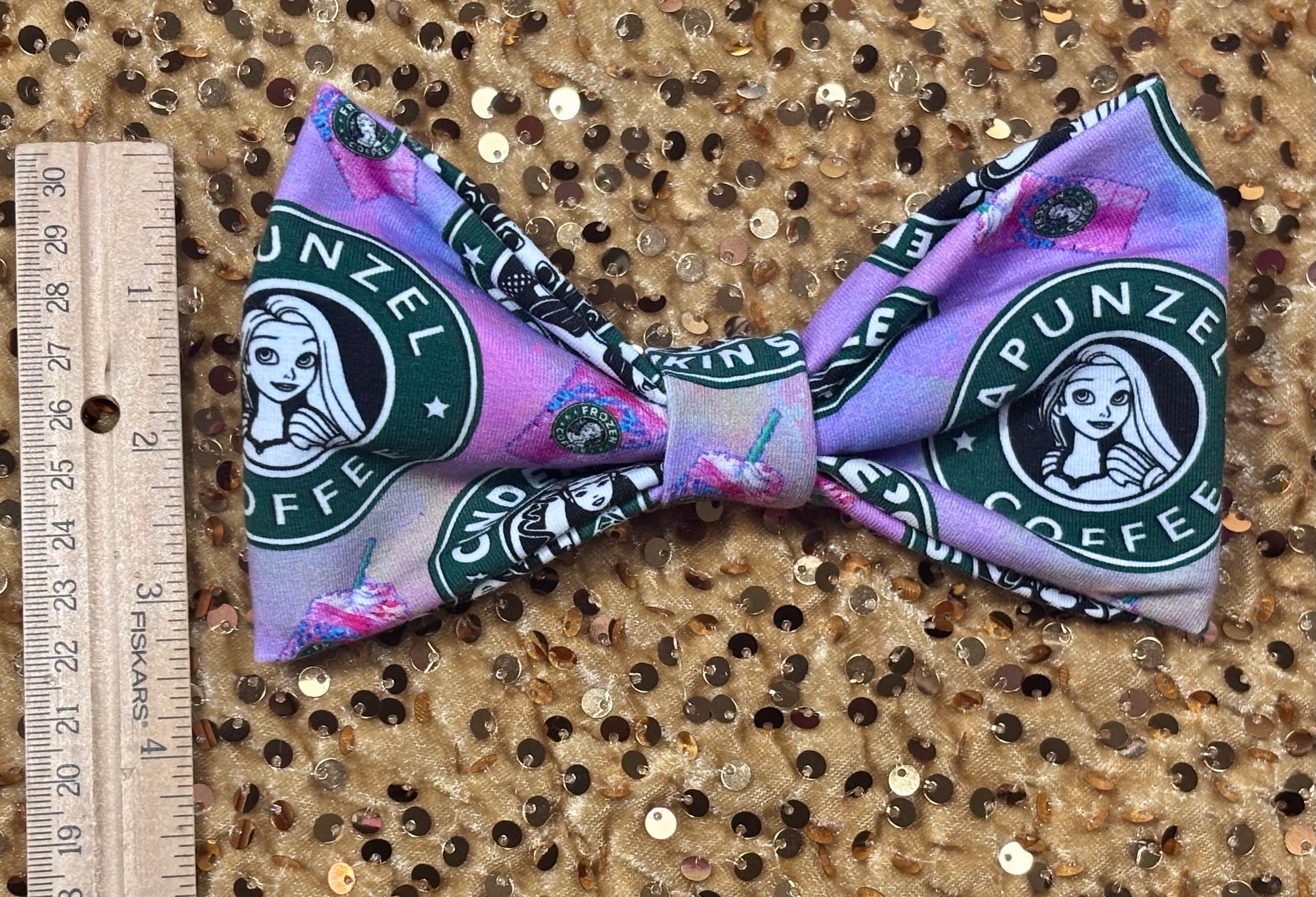 Handmade and ready to ship hairbows in a famous beloved coffee company's image but with princesses on the bow. Shown with a ruler for reference.