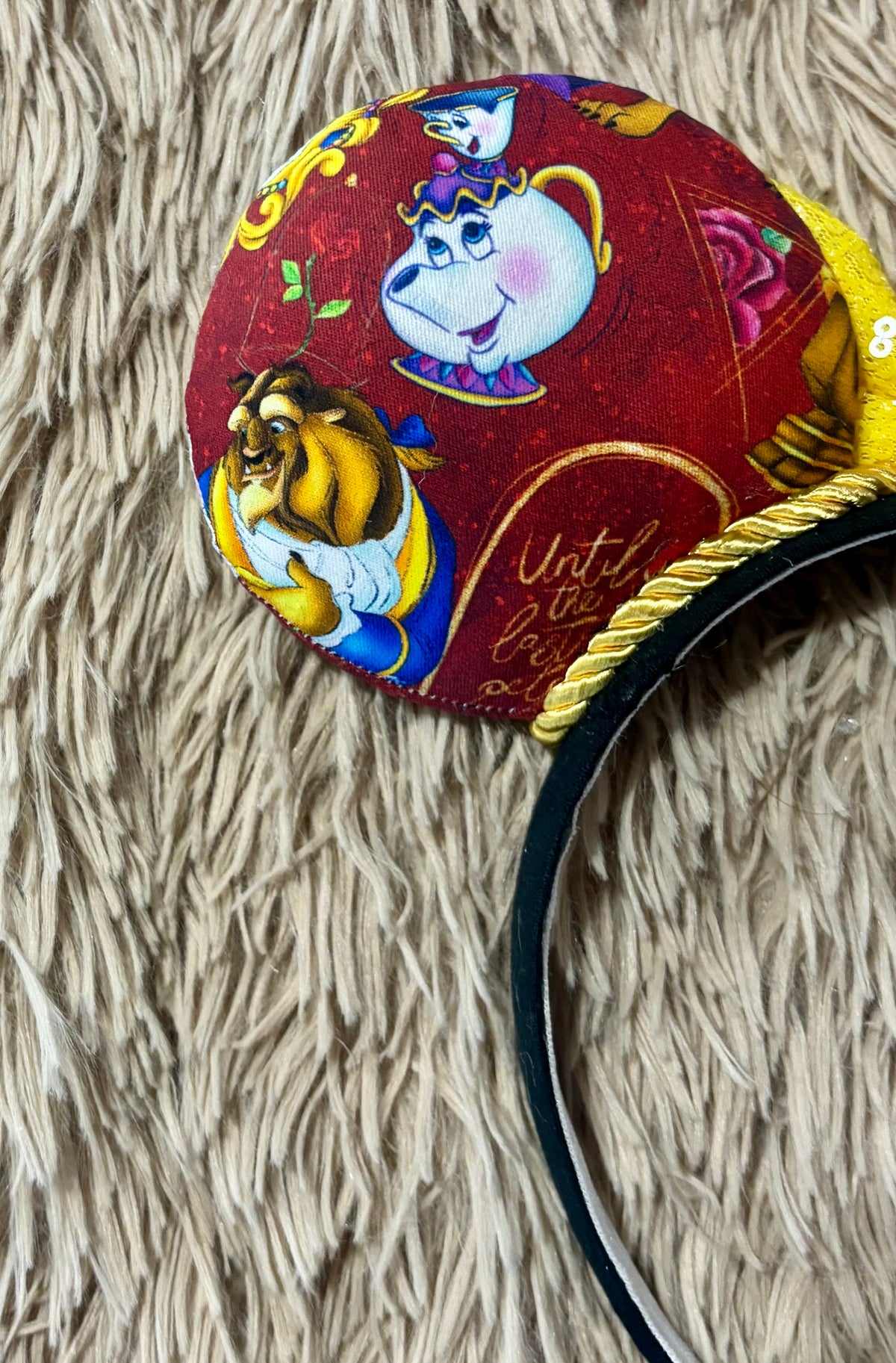 Handmade ear headband featuring a large yellow bow and multicolor print with Belle and the Beast.