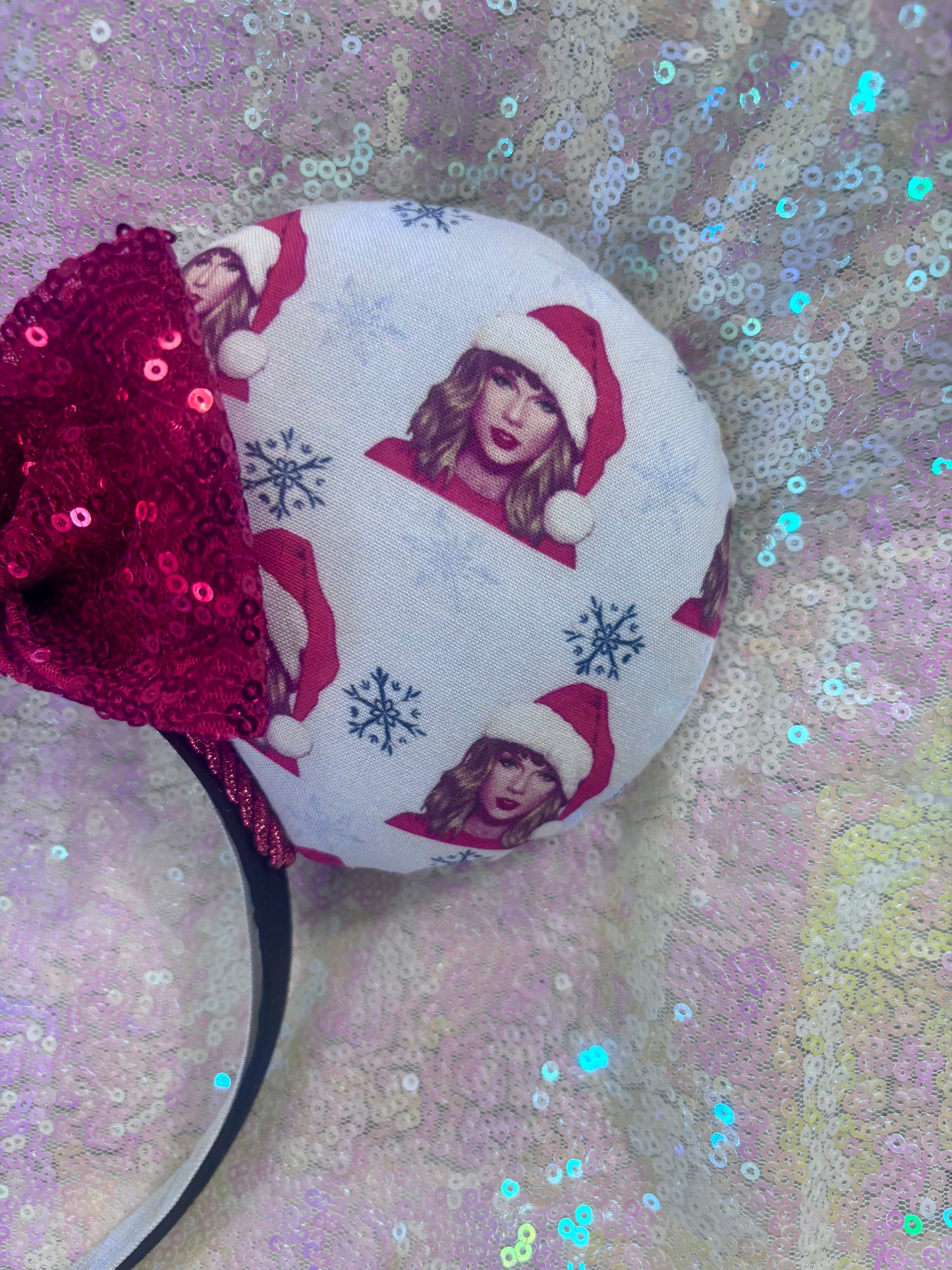 Mouse ear headband with sequin bow and festive design on a glittery background