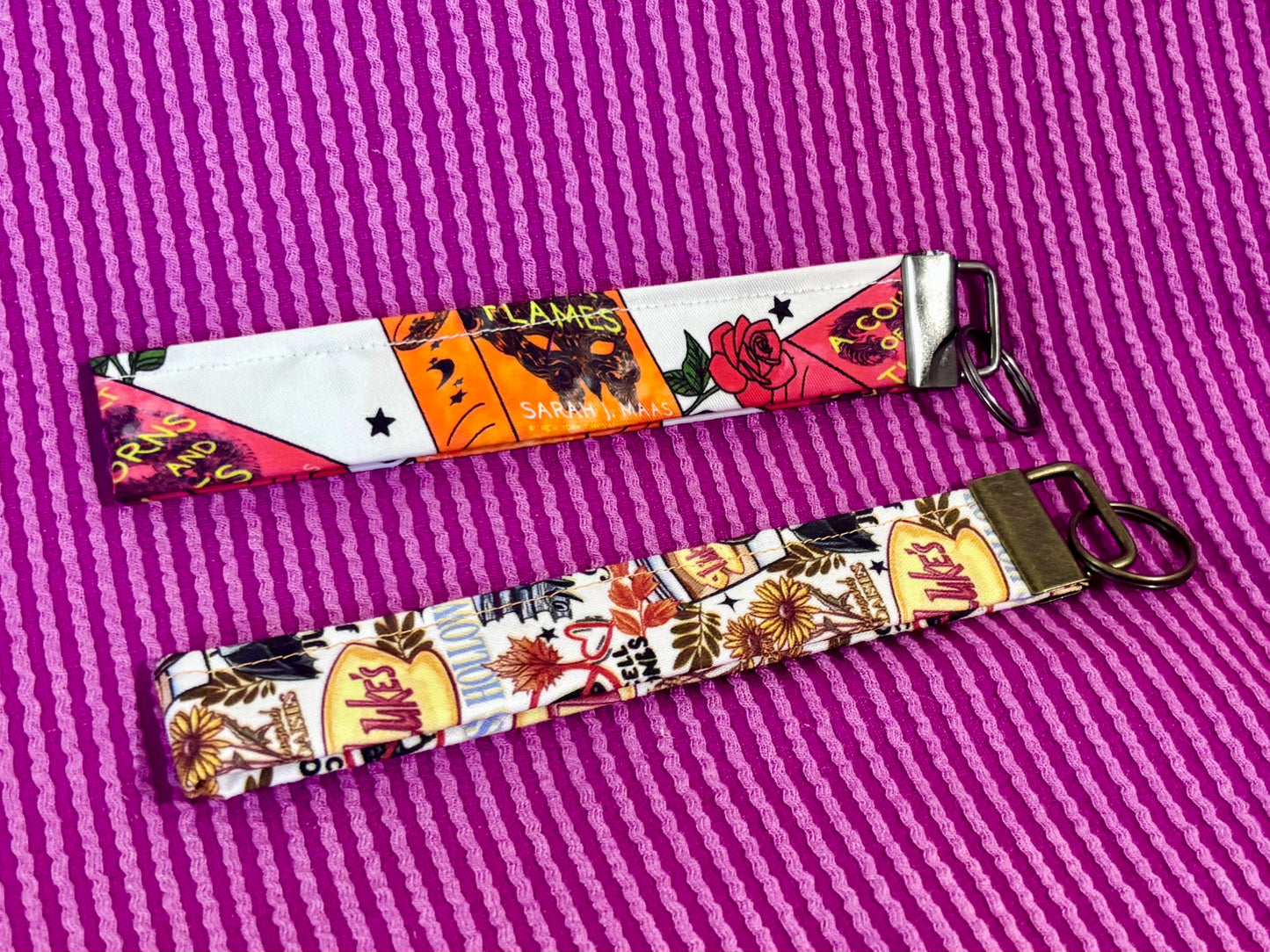 Two colorful keychains on a purple textured background