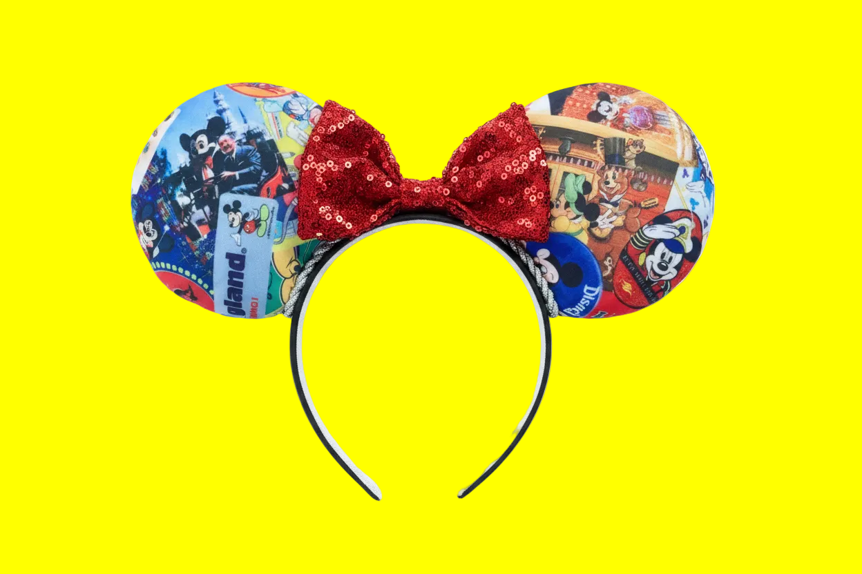 Handmade and ready to ship custom and unique ears that have cartoon and park images on them on the front and back of the ears. Silver twisted trim is along the inner ears with a red sequin bow on a black poly cotton universal sized headband.