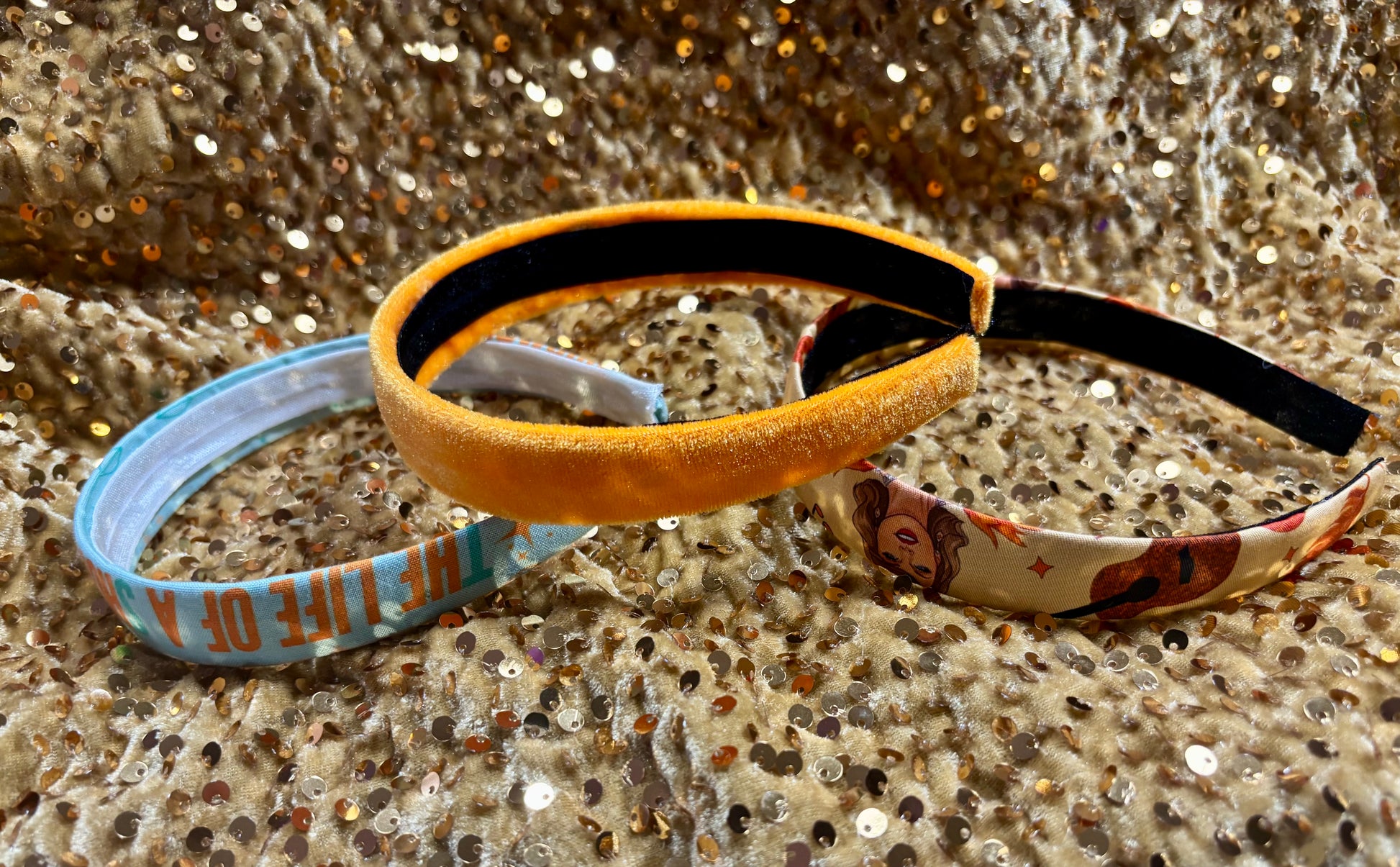 Three colorful headbands on a glittery surface. Handmade and ready to ship.