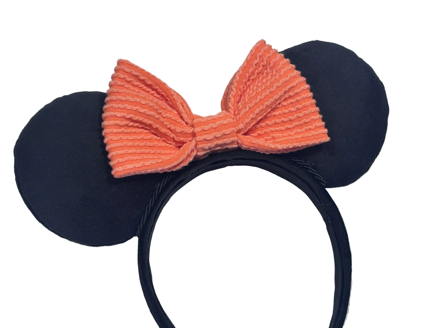 Velvet Black mouse ears with an orange bow on a textured gray background