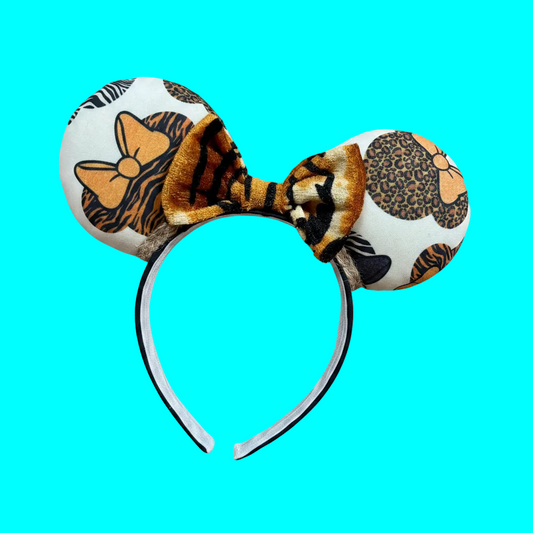 Safari mouse prints with bows are on the Mouse Ear headband with a soft tiger striped bow. You can request any color sequin bow in your order by leaving a note if you prefer one of those instead. Handmade and ready to ship with fabric on both the front and the back of mouse ears. The set has a jute twisted trim along the inner ears. Ears are on a black poly cotton universal sized headband.