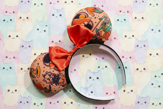 Colorful Aristocat inspired mouse ears on a black headband with black twisted trim and orange satin bow. Shown on a pastel cat pattern background.