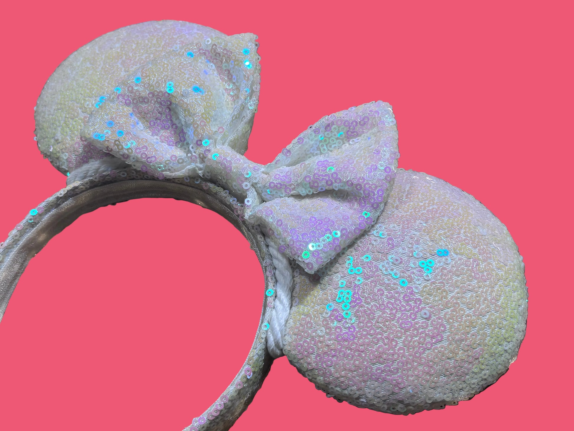 White Iridescent mouse ears with the fabric on both the front and back. The fabric is on the headband as well and is universal sized and fits most. Close up of the ears and the bow.