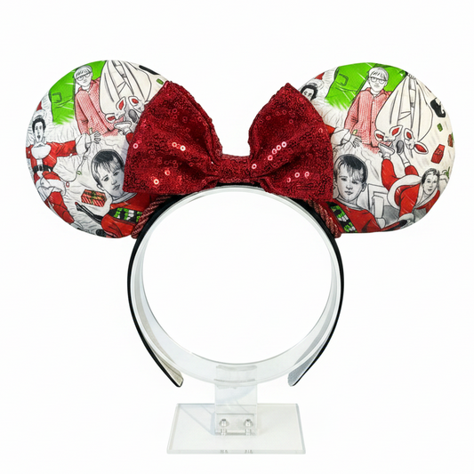Classic Christmas films inspired fabric on front, back and the headband as well. These are handmade and ready to ship mouse ears with a red sequin bow. Shown on a white background.