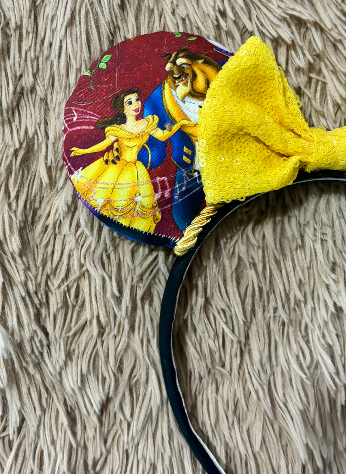 Handmade ear headband featuring a large yellow bow and multicolor print with Belle and the Beast.