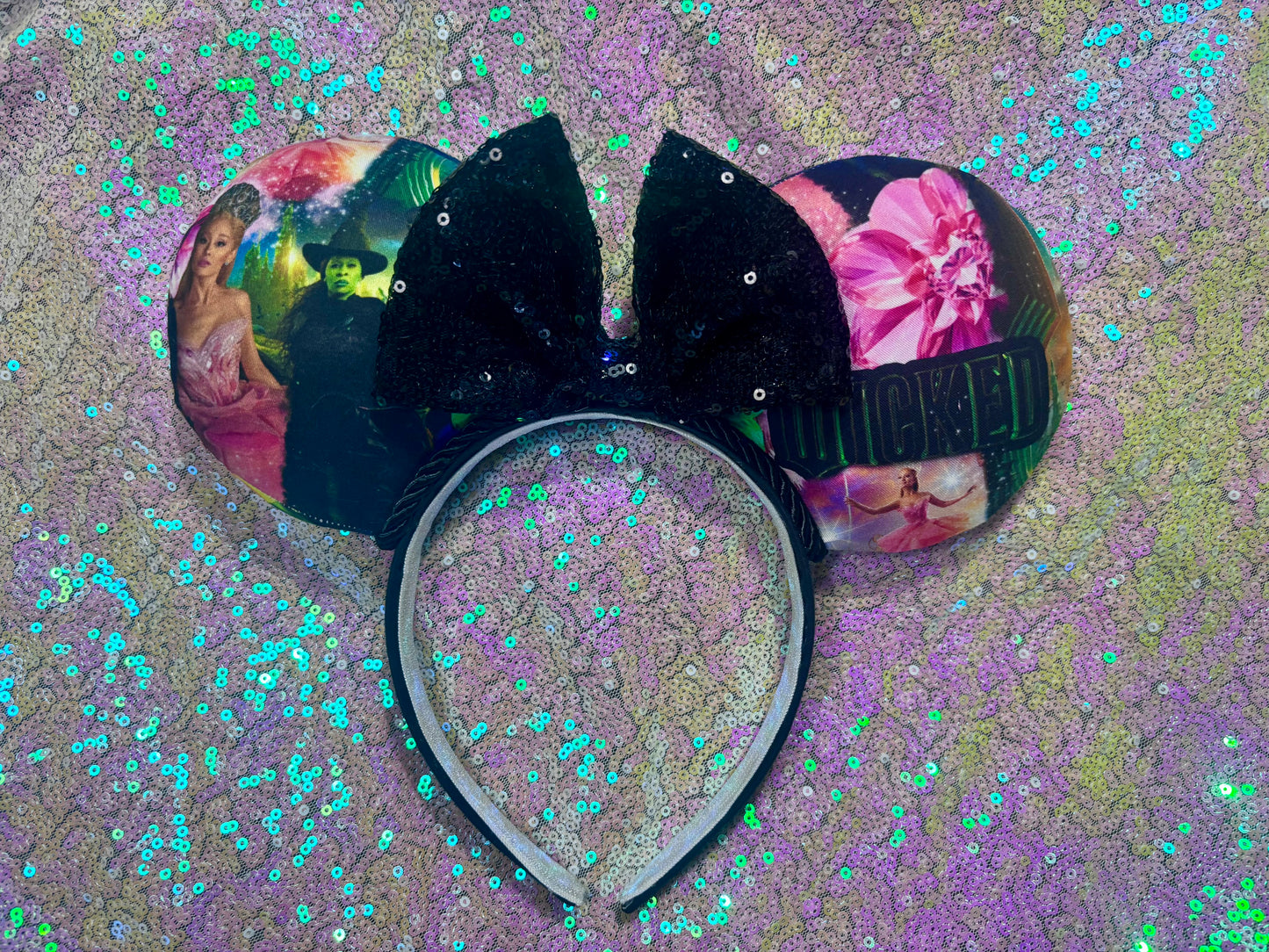 Black bow with floral designs on a glittery purple background