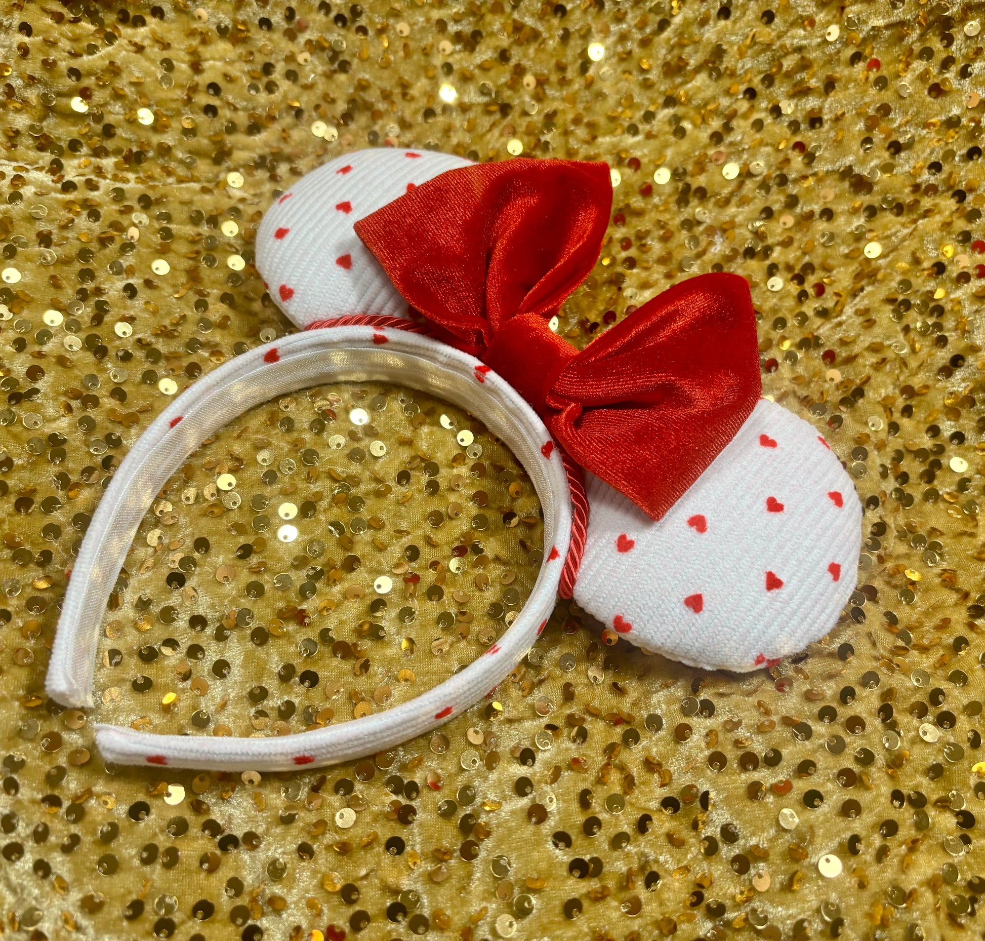 White headband with red bow and heart patterns on a gold glitter background. Handmade and ready to ship.
