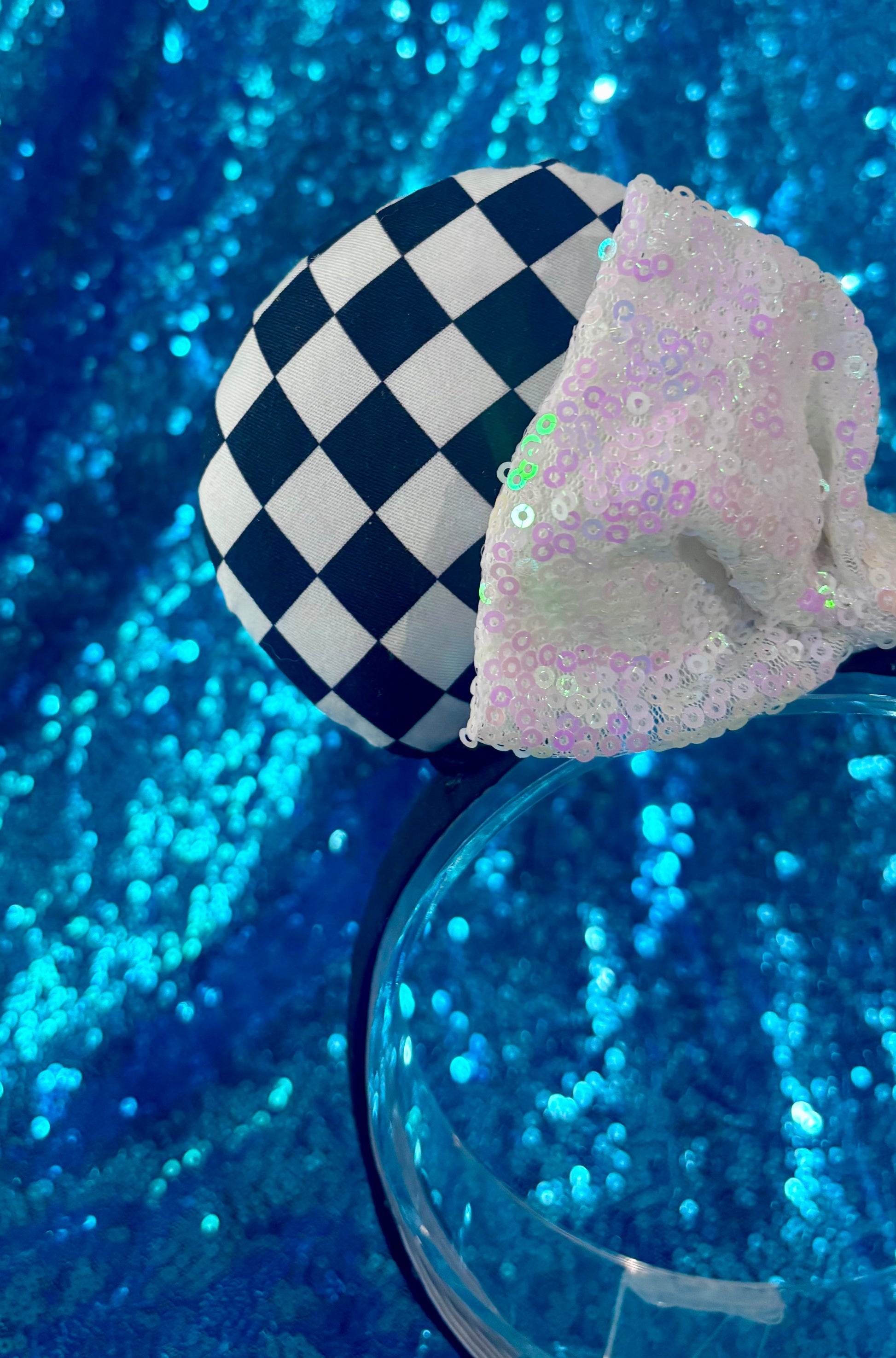 Checkered and sequined headband on a blue glittery background