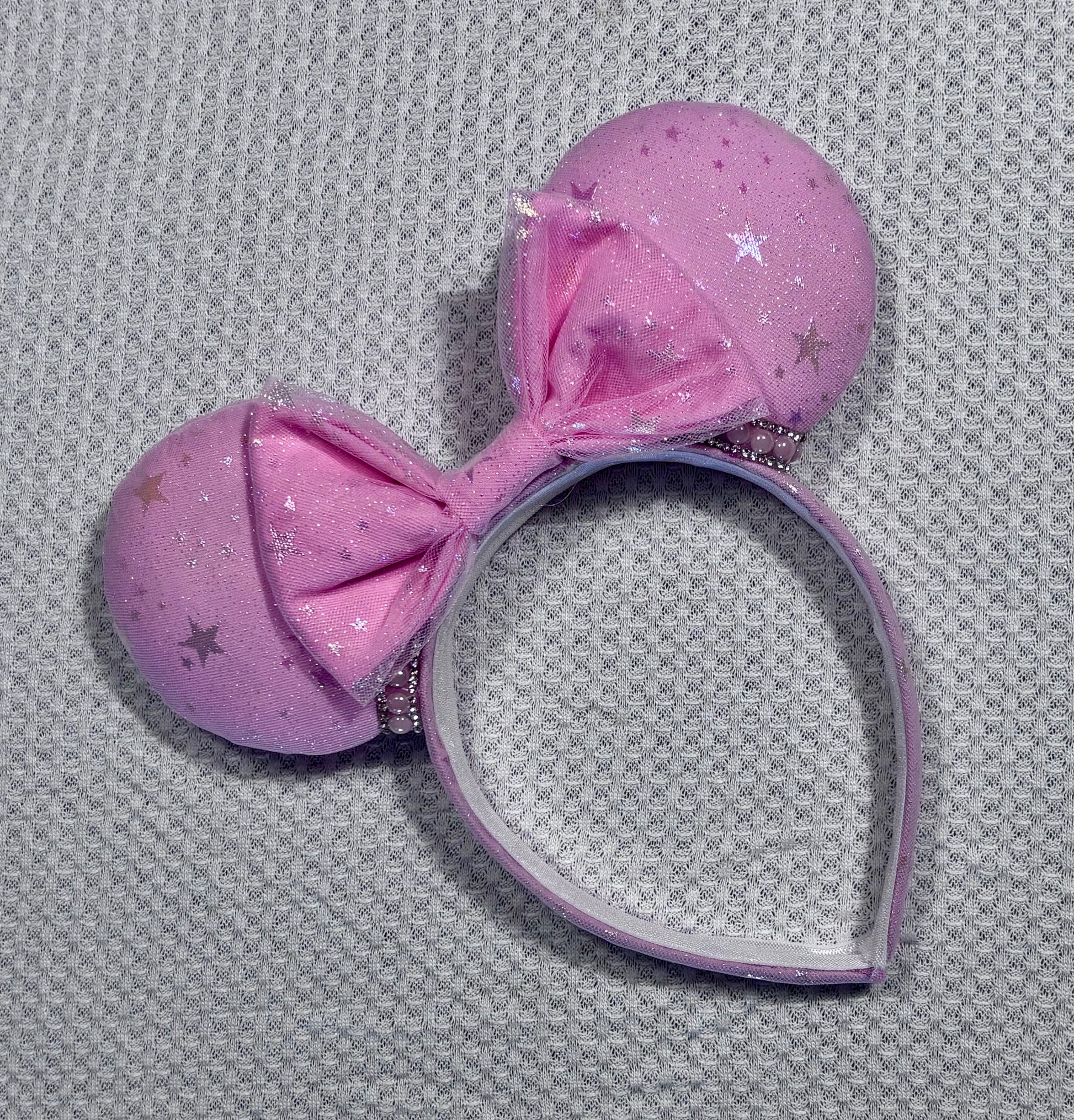 Handmade and ready to ship Pink Sparkling Iridescent fabric on pink to make mouse ears with the fabric on both the front and back along with the headband the is universal sized and fits most. The set has a matching bow, but you can request any sequin color in your order and I'll attach it. Item is shown on a white background.