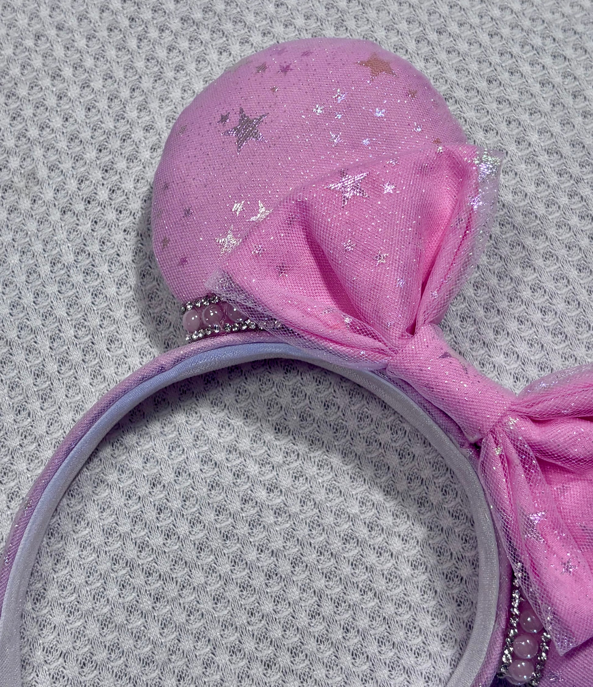 Handmade and ready to ship Pink Sparkling Iridescent fabric on pink to make mouse ears with the fabric on both the front and back along with the headband the is universal sized and fits most. The set has a matching bow, but you can request any sequin color in your order and I'll attach it. Item is shown on a white background.
