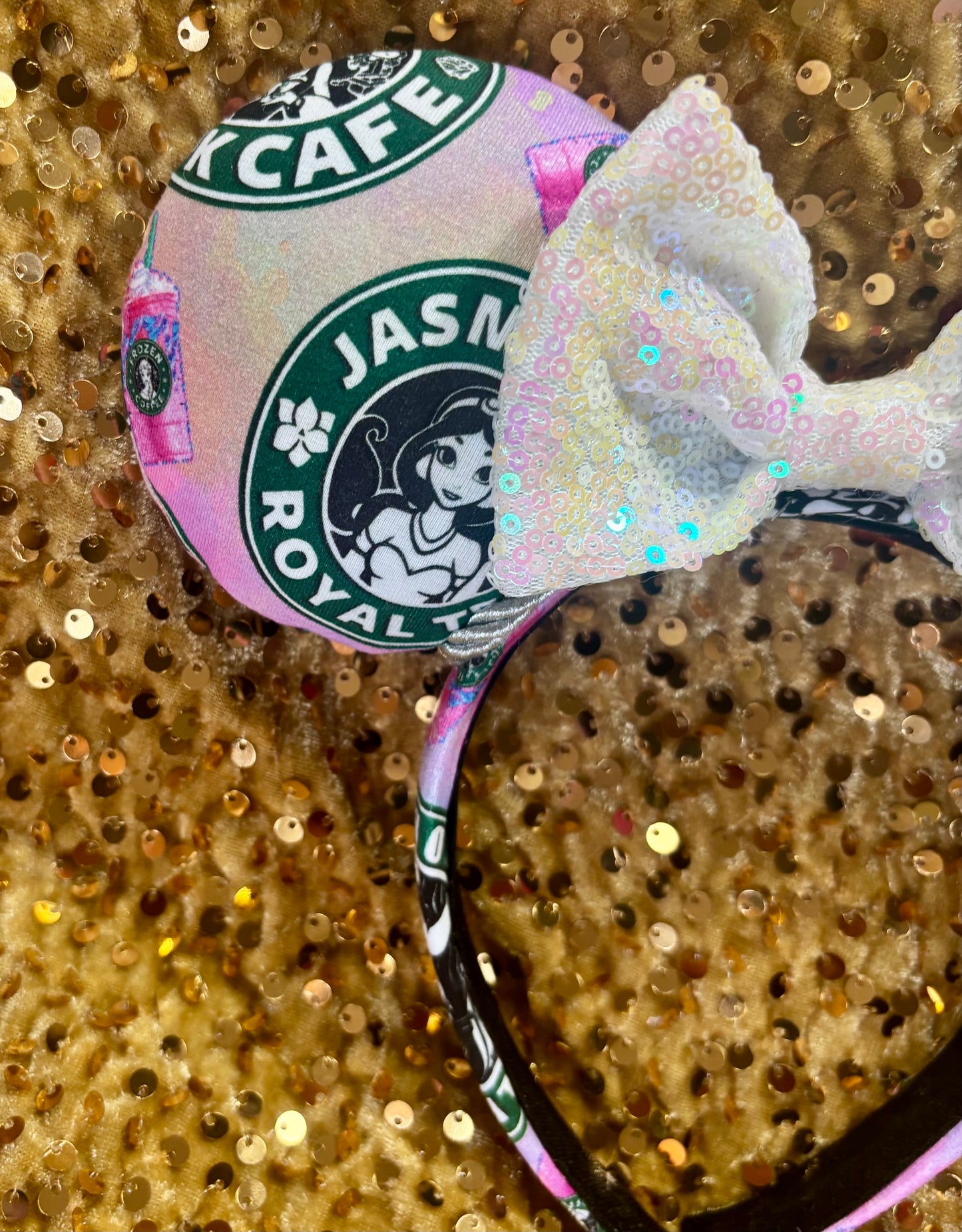 Handmade and ready to ship custom ears with popular coffee themed with princesses on fabric. Close up of front ear. Shown on a gold sequin background